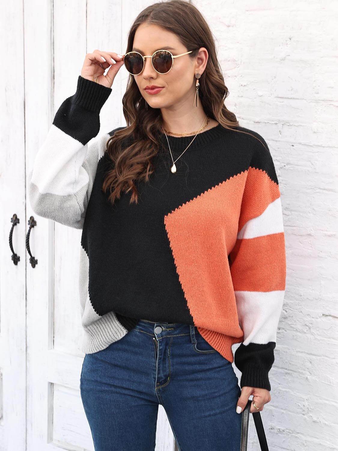 Color Block Round Neck Sweater featuring a stylish design in black, orange, and gray with a round neck and slightly stretchy fabric.