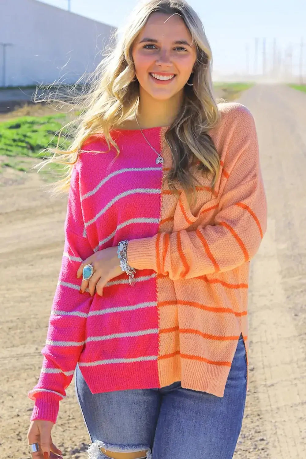 Striped Pocketed Dropper Shoulder Sweater worn by a smiling woman outdoors on a dirt path.